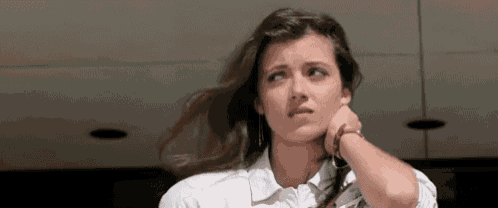 a woman with long hair is holding her hand to her ear .
