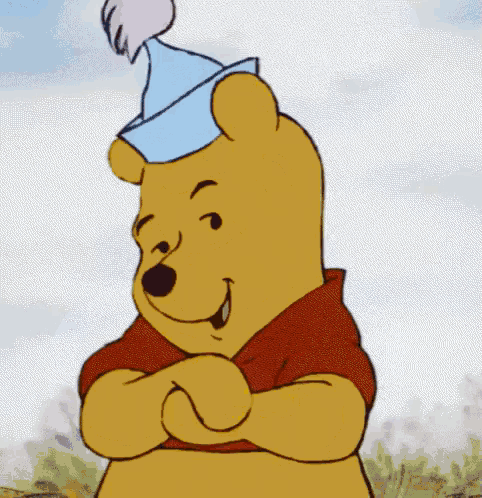 winnie the pooh is wearing a blue party hat and smiling .