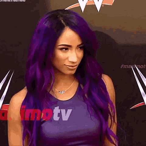 a woman with purple hair is standing in front of a sign that says imtv