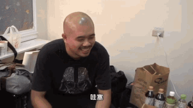 a man wearing a darth vader t-shirt is smiling