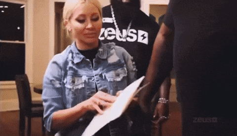 a woman in a denim jacket is holding a piece of paper in her hand .