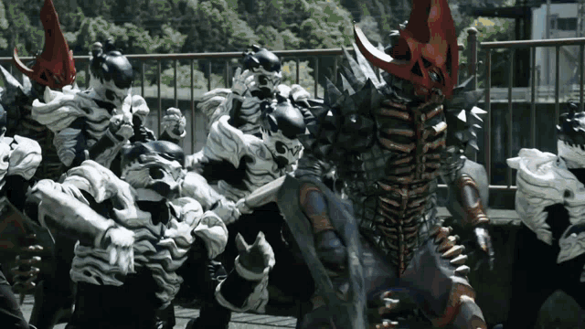 a group of monsters are standing in front of a metal fence