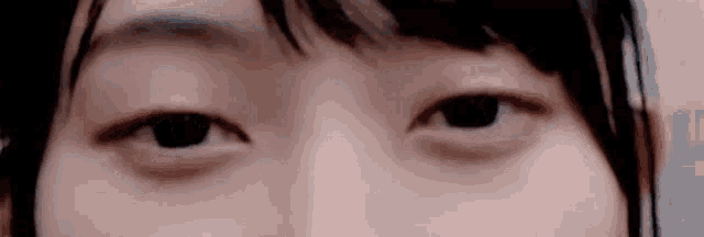 a close up of a woman 's eyes looking at the camera with a blurry background .