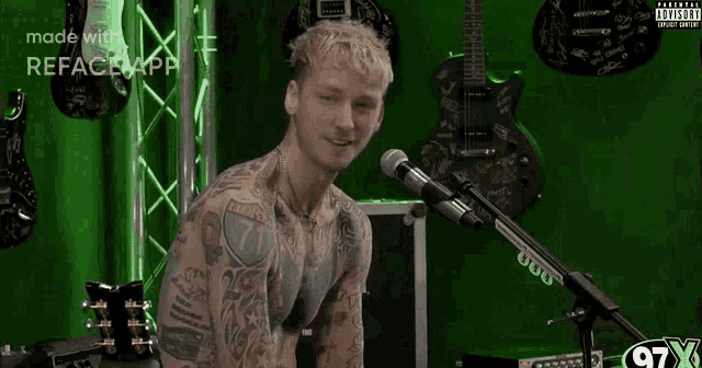 a man with tattoos is smiling in front of a microphone that says 97x