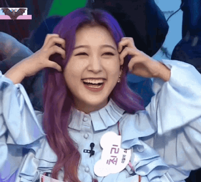 a woman with purple hair and a name tag that says ' a ' on it