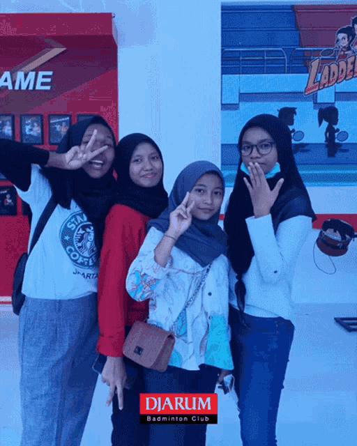 three girls are posing for a picture in front of a sign that says djarum