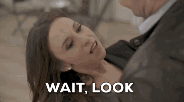 a woman laying on the floor next to a man with the words wait look written on the bottom