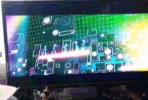 a computer monitor with a rainbow colored screen and a few letters on it