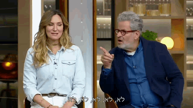 a man and a woman are sitting next to each other and the man is pointing at the woman in hebrew