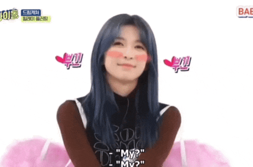 a girl with blue hair is making a funny face with her hands on her cheeks