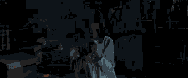 a woman is screaming in a dark room with a man in the background