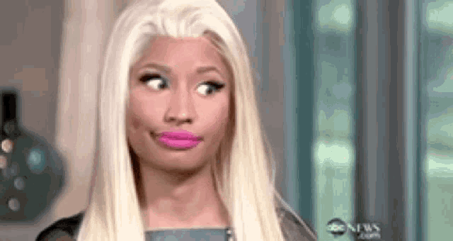 a woman with blonde hair and pink lipstick is making a face .