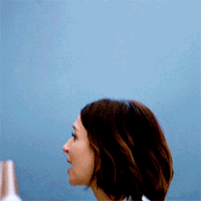 a close up of a woman 's face against a blue background