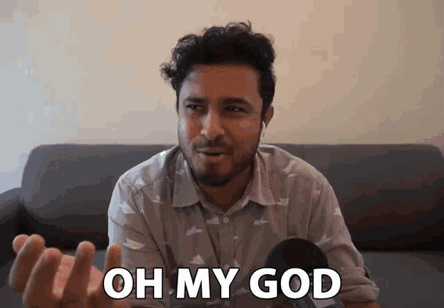 a man sitting on a couch with the words oh my god behind him