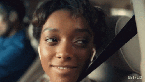 a close up of a woman in a car with a netflix logo on the bottom right