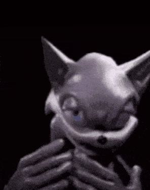 a cartoon cat with a big smile on its face is smiling in the dark .