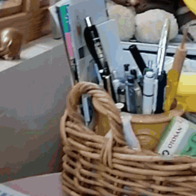 a wicker basket filled with office supplies including a box of otomax