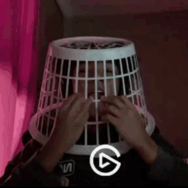 a person wearing a laundry basket on their head with the letter s on their shirt