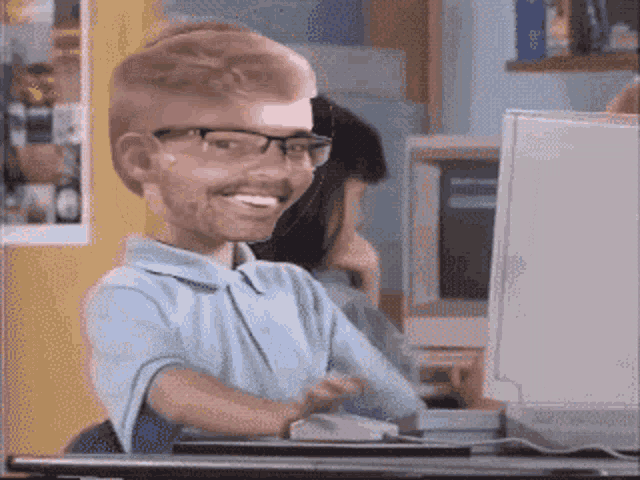 a caricature of a man wearing glasses and a blue shirt sitting in front of a computer