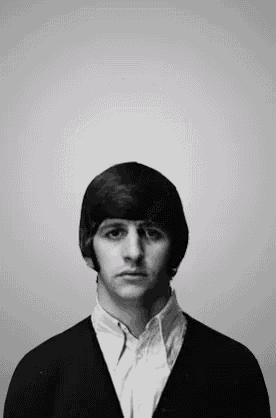 a black and white photo of a young man wearing a cardigan and a button down shirt .
