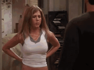 a woman in a white tank top is standing in front of a man in a black shirt .