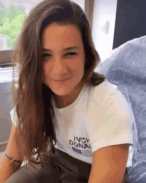 a woman wearing a white shirt that says avck donal on it