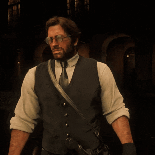 a man with a beard wearing glasses and a vest