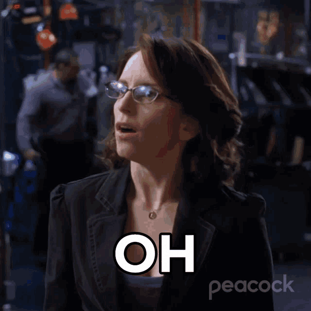 a woman wearing glasses and a peacock logo