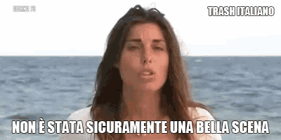 a woman is standing in front of the ocean with a caption in italian
