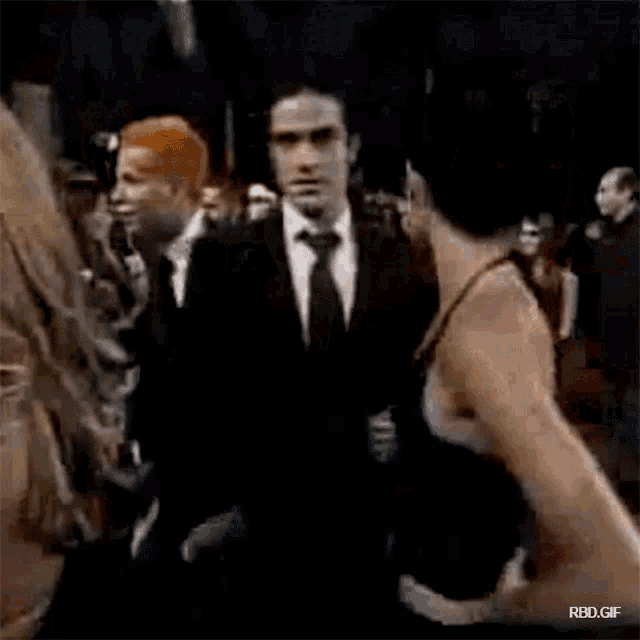 a man and a woman are standing next to each other in a crowded room .