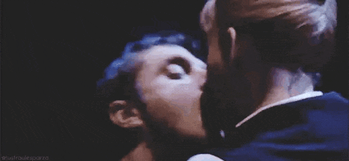 a man and a woman are kissing in the dark .