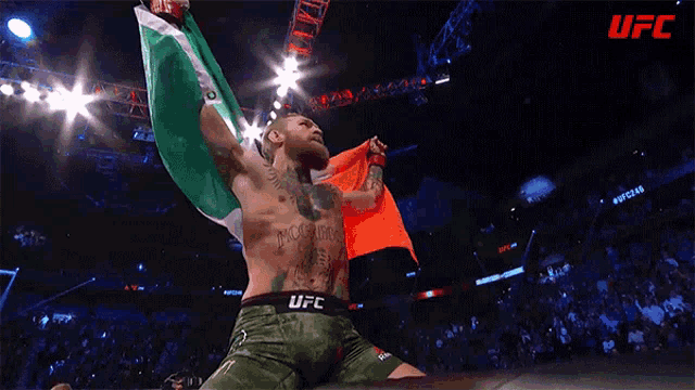 a man is holding an irish flag in a ufc ring .