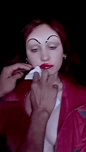 a close up of a woman 's face with a hand covering her mouth