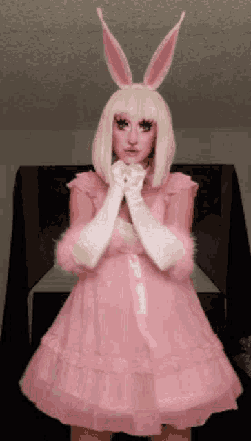 a woman in a pink dress with bunny ears and white gloves