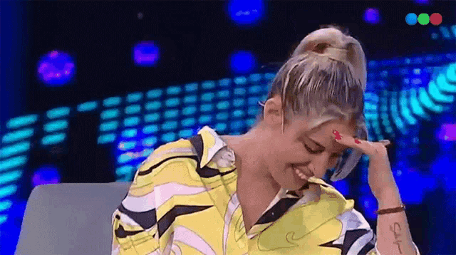 a woman with a tattoo on her wrist that says say is smiling