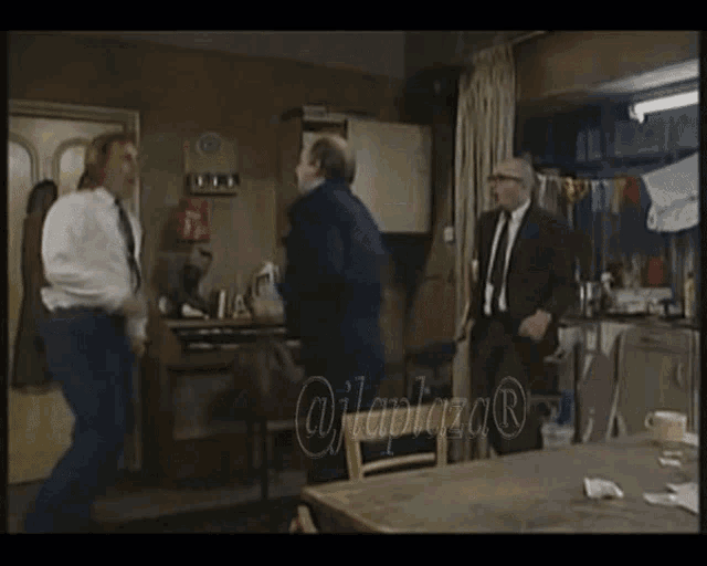 a man in a suit and tie is jumping in the air in a room with a watermark that says ujlaplaza