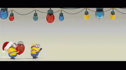 a couple of minions wearing santa hats are standing under a string of christmas lights