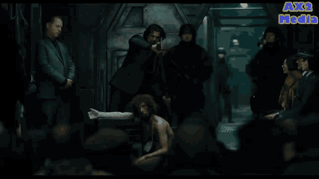 a group of people are gathered in a dark room with the words ax2 media in the upper right corner