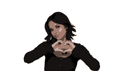 a woman in a black top is making a heart shape with her hands