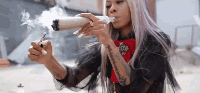 a woman with a tattoo on her arm is smoking