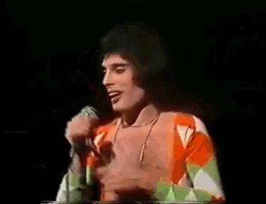 a man is singing into a microphone on a stage .