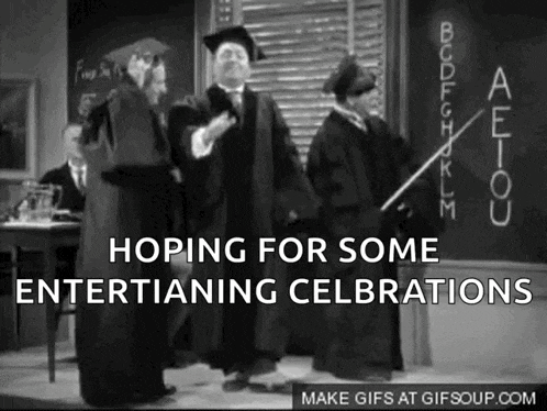 a black and white photo of a man in a graduation cap and gown standing in front of a chalkboard .