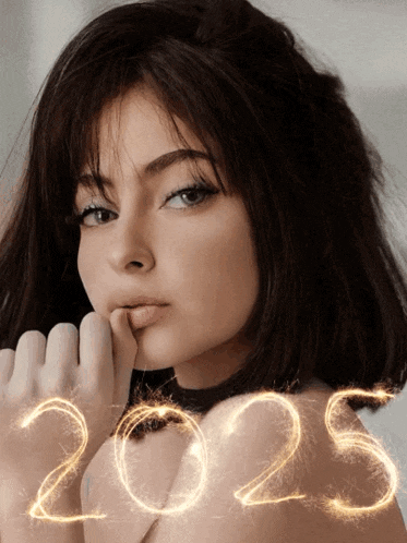 a woman 's face is shown with the year 2025 written in sparklers