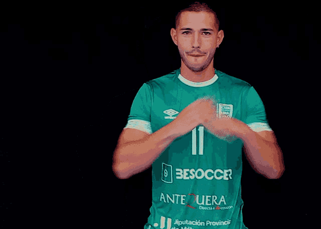 a man wearing a green shirt that says besoccer on the front