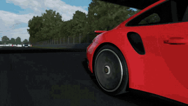 a red sports car is driving under a bridge with a sign that says xbox one
