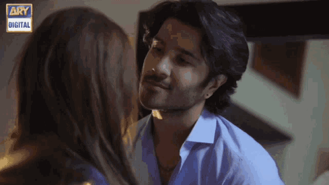 a man and a woman are kissing and the man is wearing a blue shirt that says ary digital