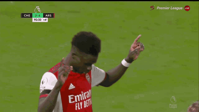 a soccer player in a red emirates fly better jersey