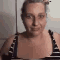 a woman in a striped bikini top is making a funny face .