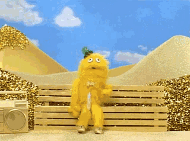 a yellow monster is sitting on a wooden bench