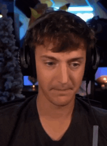 a man wearing headphones is making a funny face while looking at the camera .